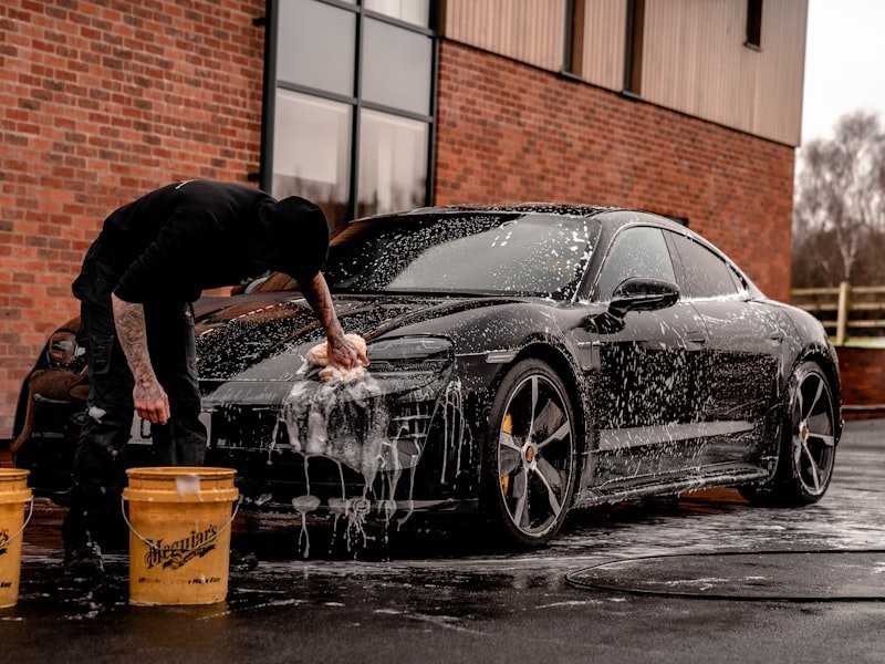 A vehicle being washed professionally with thick active snow foam