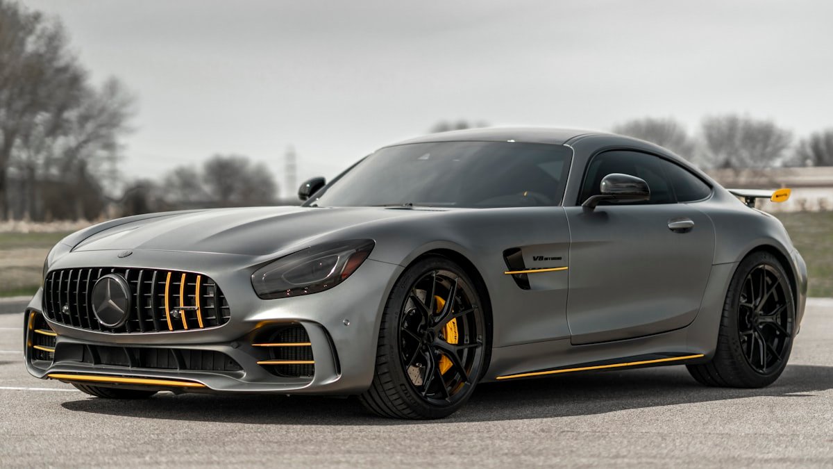 A professionally detailed and polished luxury sports car reflecting sunset sky